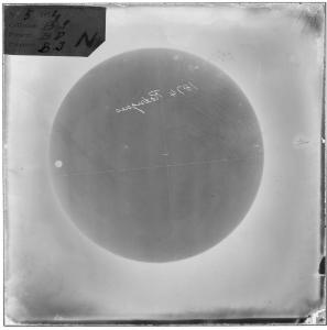 A photographic negative plate showing the dark circle of the sun with the small disc of Venus, 1874.